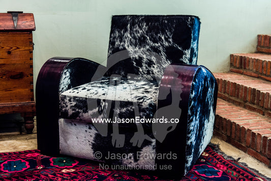 An inviting elegant Nguni Skin Chair in a winery guest lounge. Fairview Wine Estate, Stellenbosch, Western Cape, South Africa.