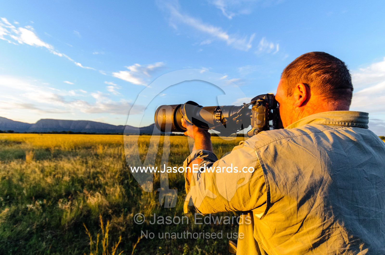 A photographer captures a savannah plain at sunset. Waterberg Mountains, Entabeni Game Reserve, Limpopo Province, South Africa.