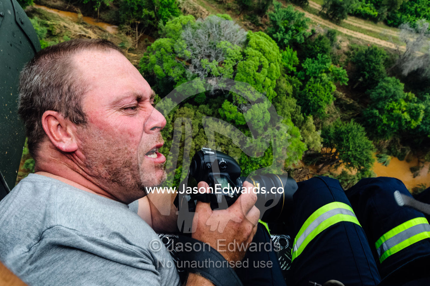 Photographer Jason Edwards filming rescue crews in a helicopter. The Lowveld Area, Olifants River, Kruger National Park, South Africa.