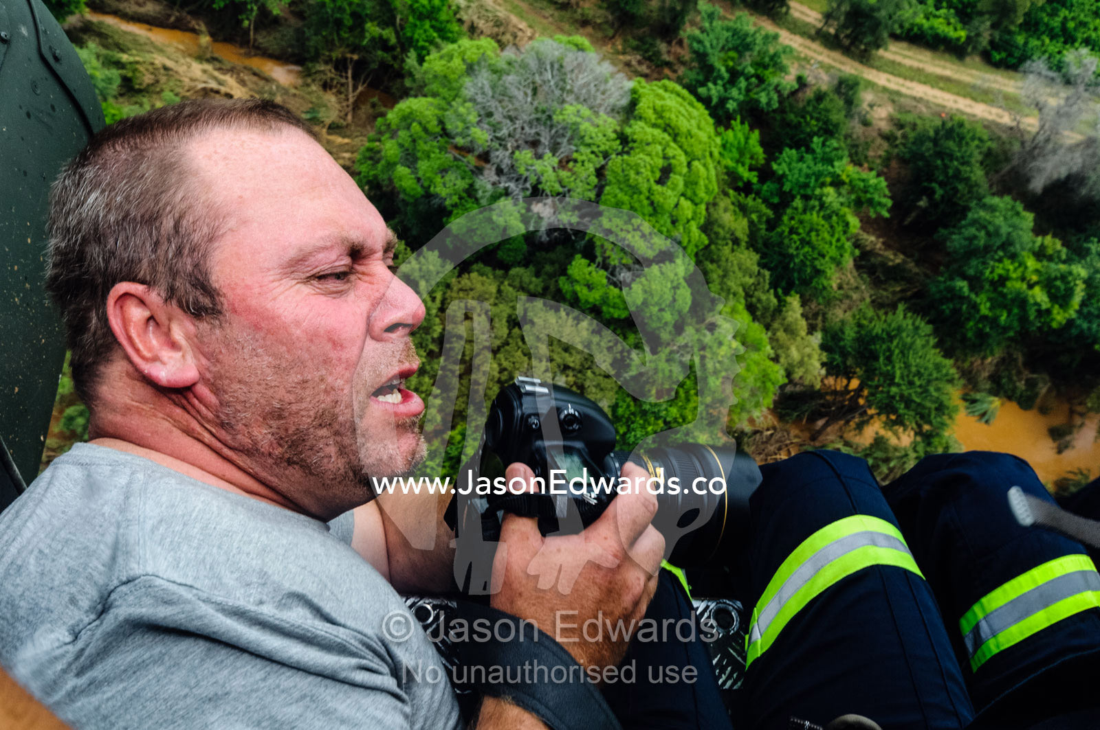 Photographer Jason Edwards filming rescue crews in a helicopter. The Lowveld Area, Olifants River, Kruger National Park, South Africa.