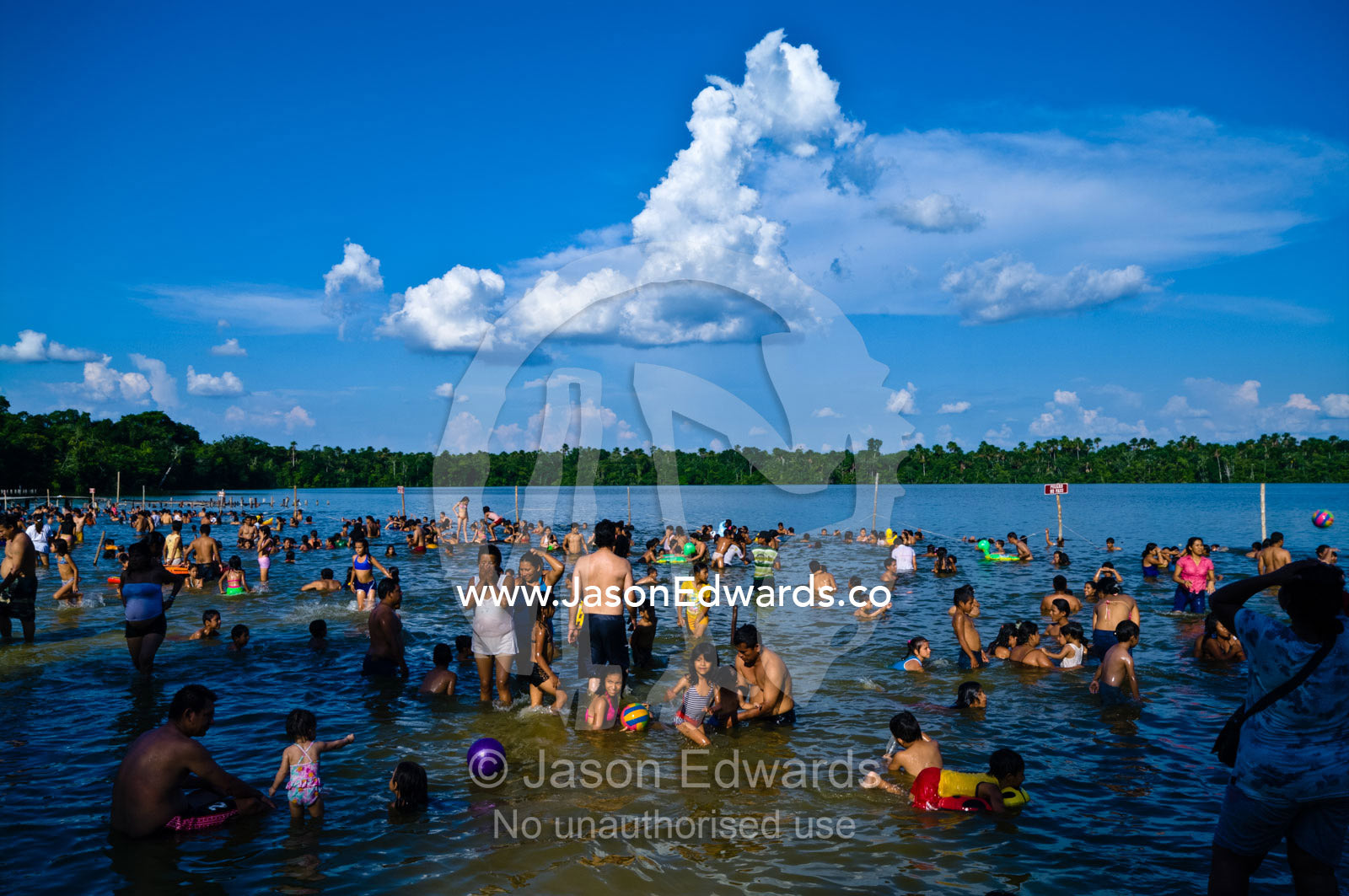 Families and children from a river town swimming in an Amazonian lake on a hot weekend afternoon. Quistococha Lake, Iquitos, Amazon Basin, Loreto Region, Maynas Province, Peru.