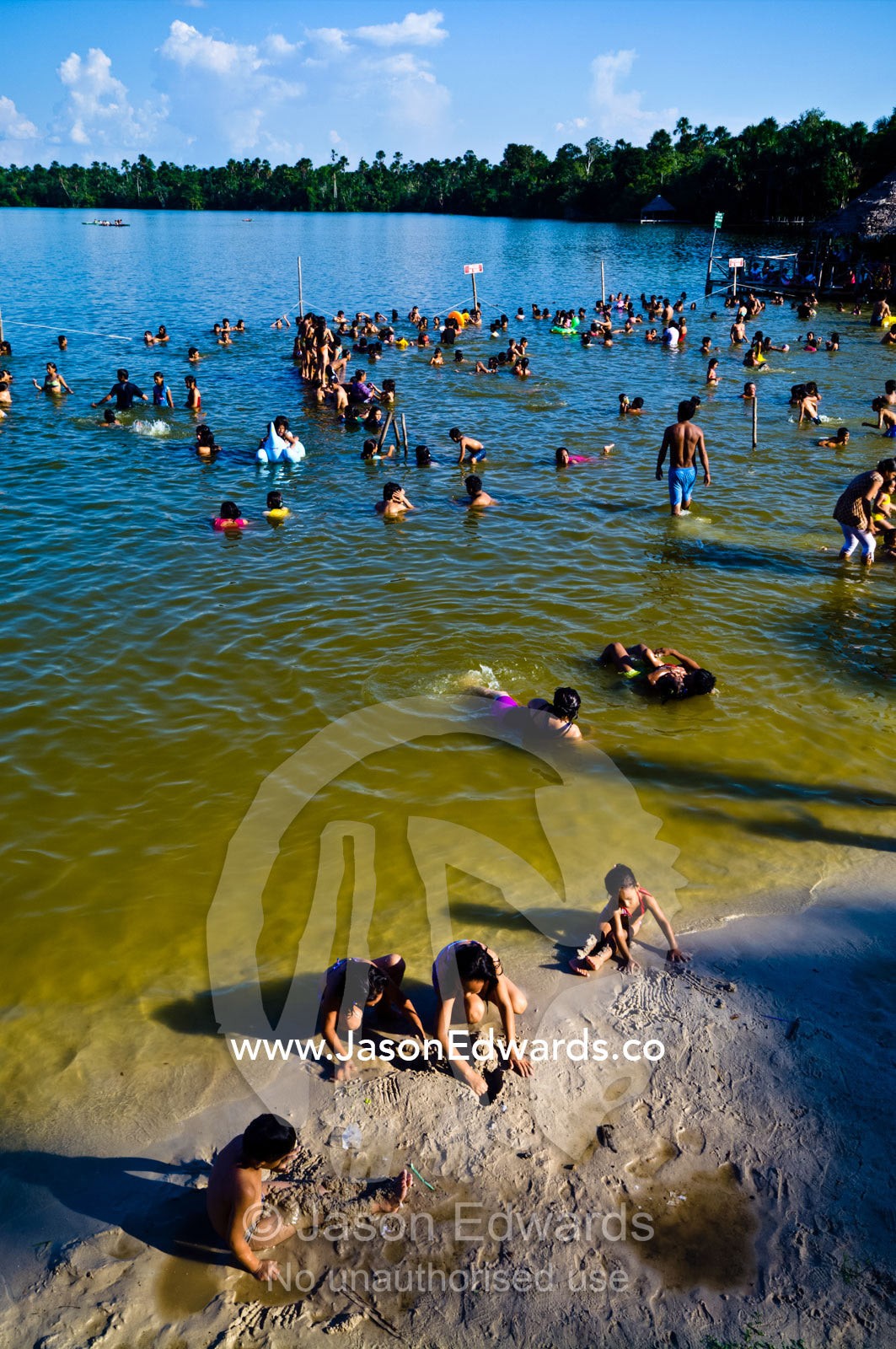 Families and children from an Amazonian river town bathing in a lake on a hot weekend afternoon. Quistococha Lake, Lago de Quistococha, Parque de Quistococha, Iquitos, Amazon Basin, Loreto Region, Maynas Province, Peru.