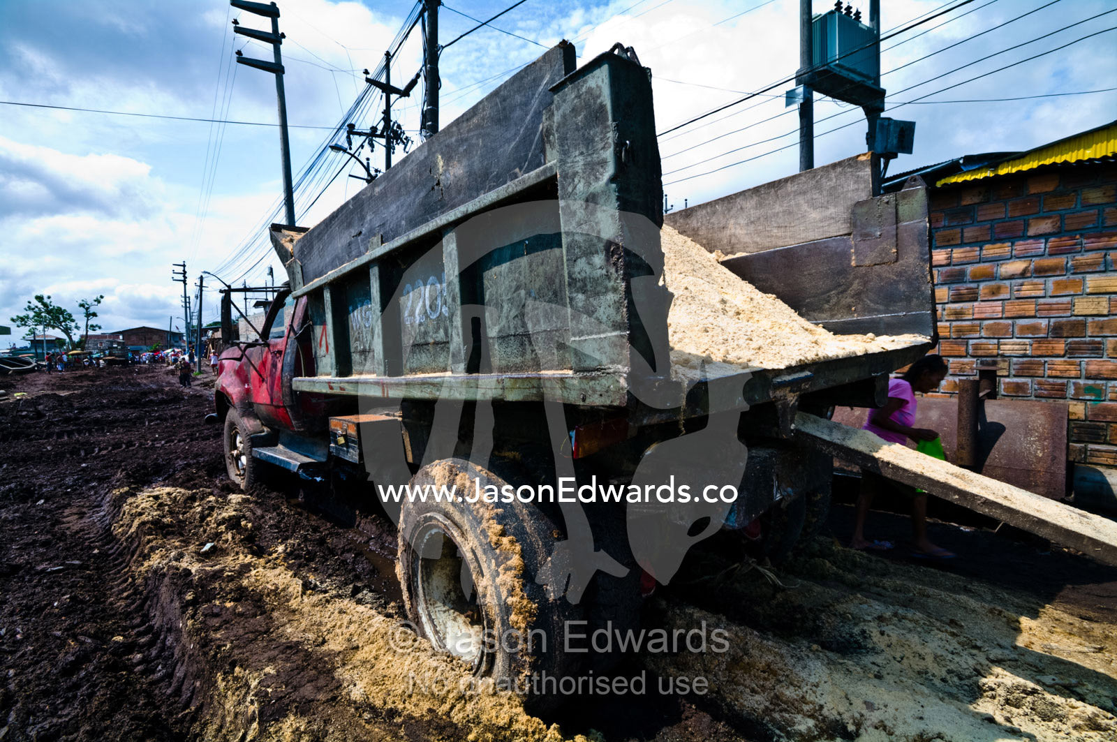 A truck takes sawdust from logging mills to recycle as flooring in village homes and farms. Puerto Masusa, Iquitos, Amazon Basin, Loreto Region, Maynas Province, Peru.