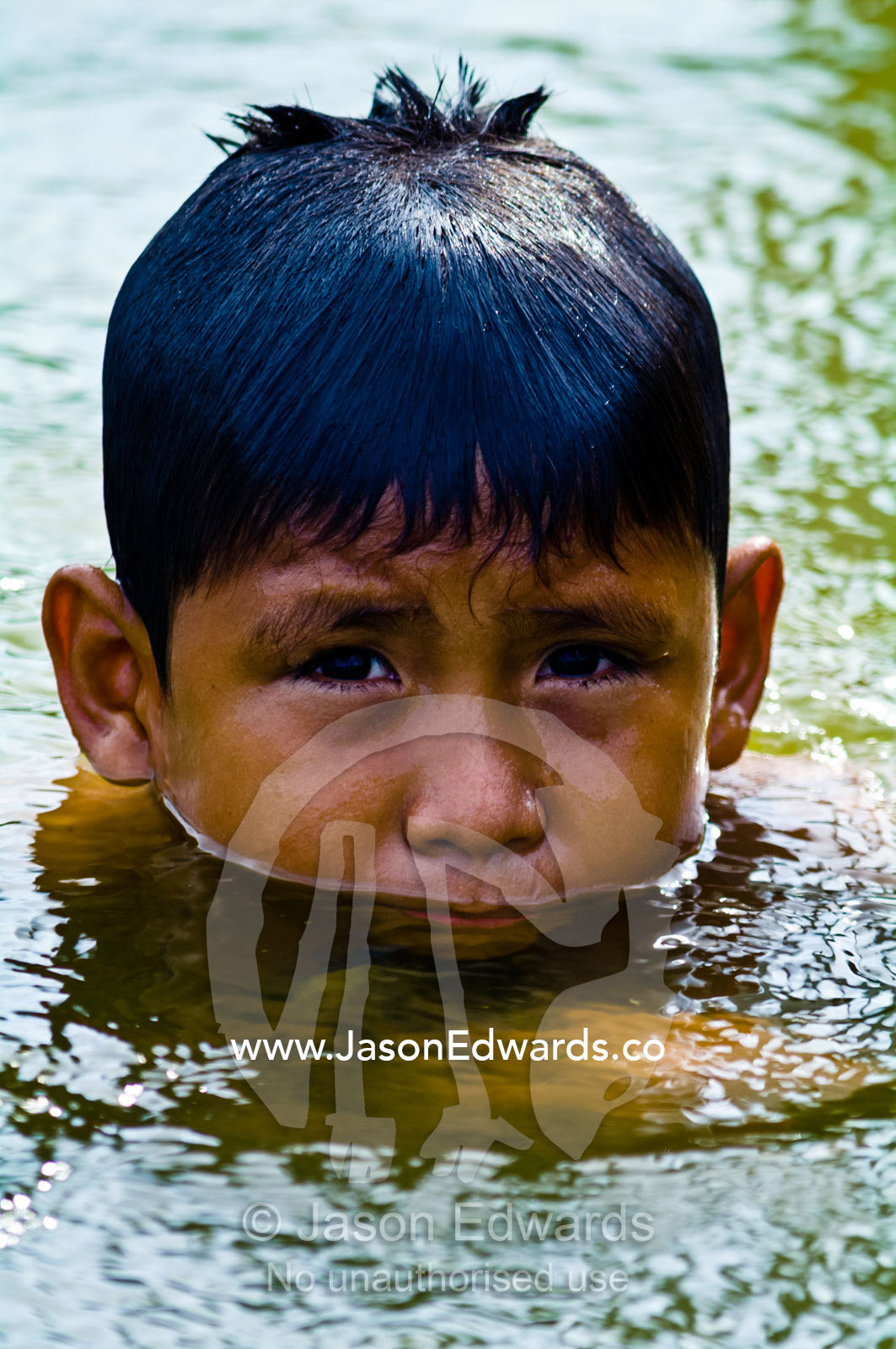 A boy from an Amazonian river town swimming in a lake on a hot weekend afternoon. Quistococha Lake, Lago de Quistococha, Parque de Quistococha, Iquitos, Amazon Basin, Loreto Region, Maynas Province, Peru.