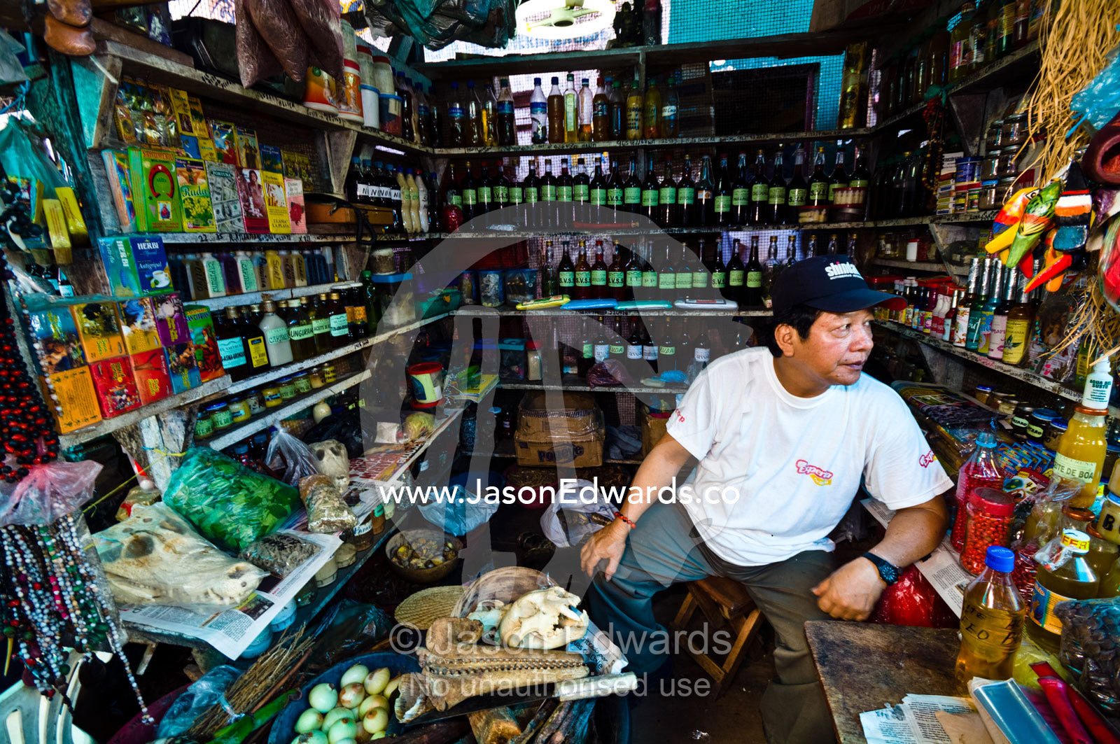 A shop owner displays Puma, Jaguar and River Dolphin skulls for sale for traditional medicine. Belen Market, Iquitos, Amazon Basin, Loreto Region, Maynas Province, Peru.