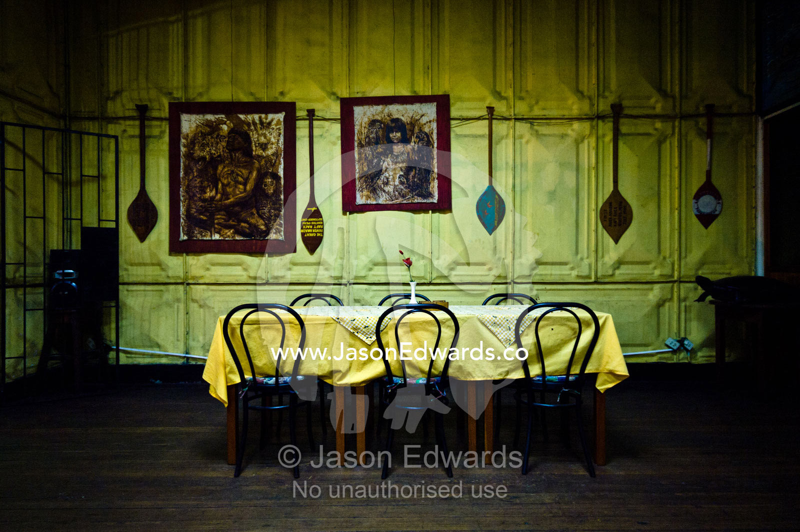 Indian canoe paddles line pressed steel walls above a dining table and chairs in a restaurant. Iquitos, Amazon Basin, Loreto Region, Maynas Province, Peru.