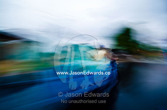 An auto rickshaw speeds along a wet road on a rainy night in an Amazon River town. Iquitos, Amazon Basin, Loreto Region, Maynas Province, Peru.