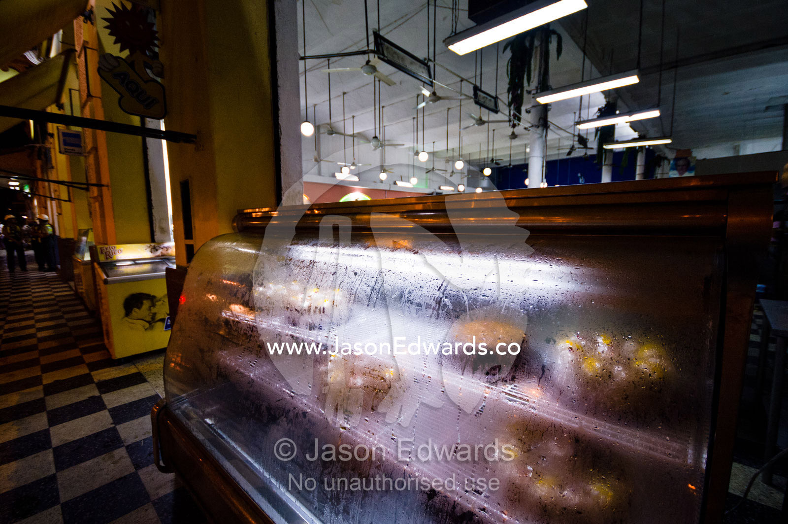 In humid weather, condensation forms on the chilled glass of a cake display case at a bakery. Iquitos, Amazon Basin, Loreto Region, Maynas Province, Peru.