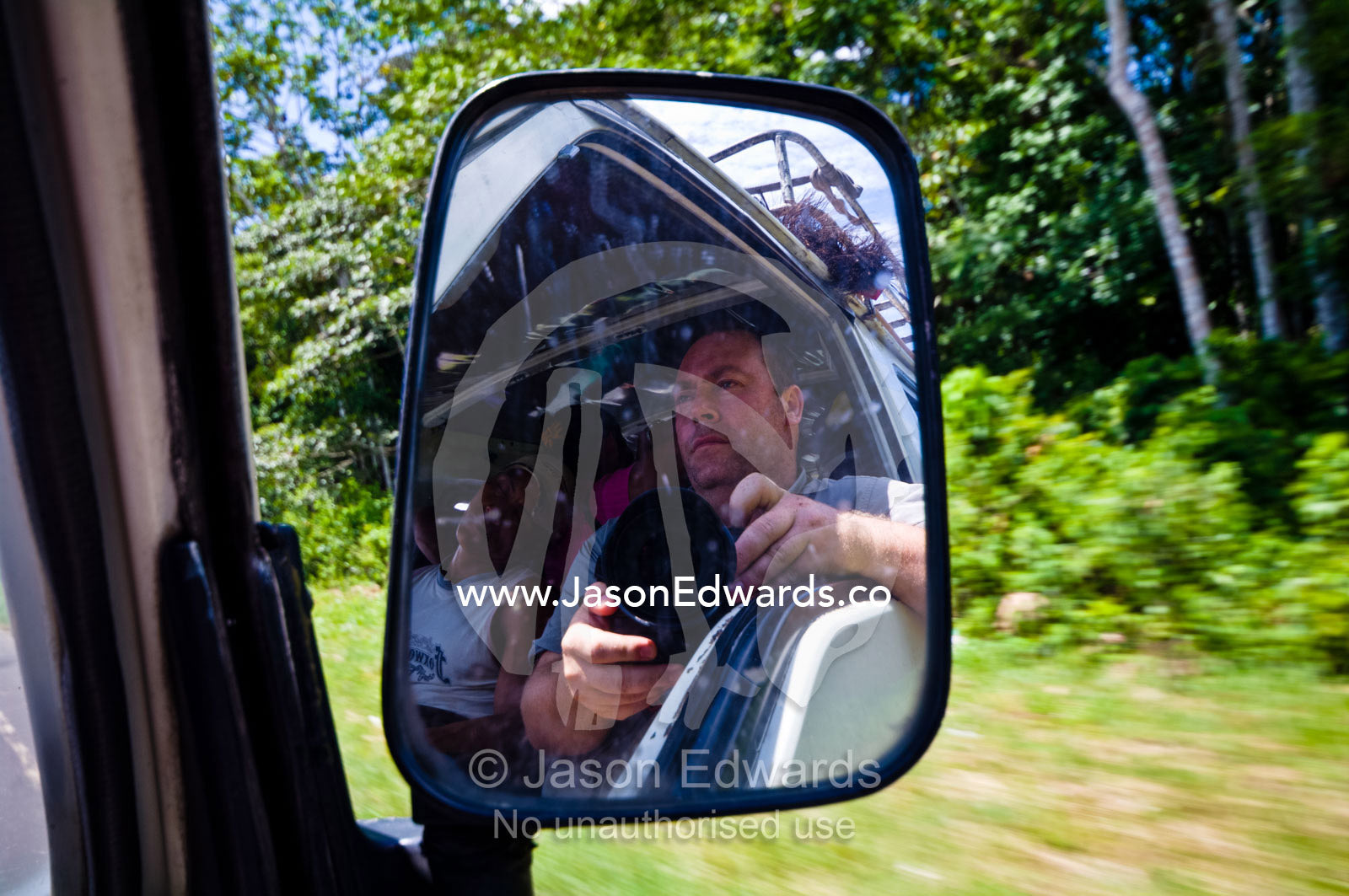 A photographer reflected in the rear view mirror of a taxi van. Amazon Basin, Loreto Region, Maynas Province, Peru.