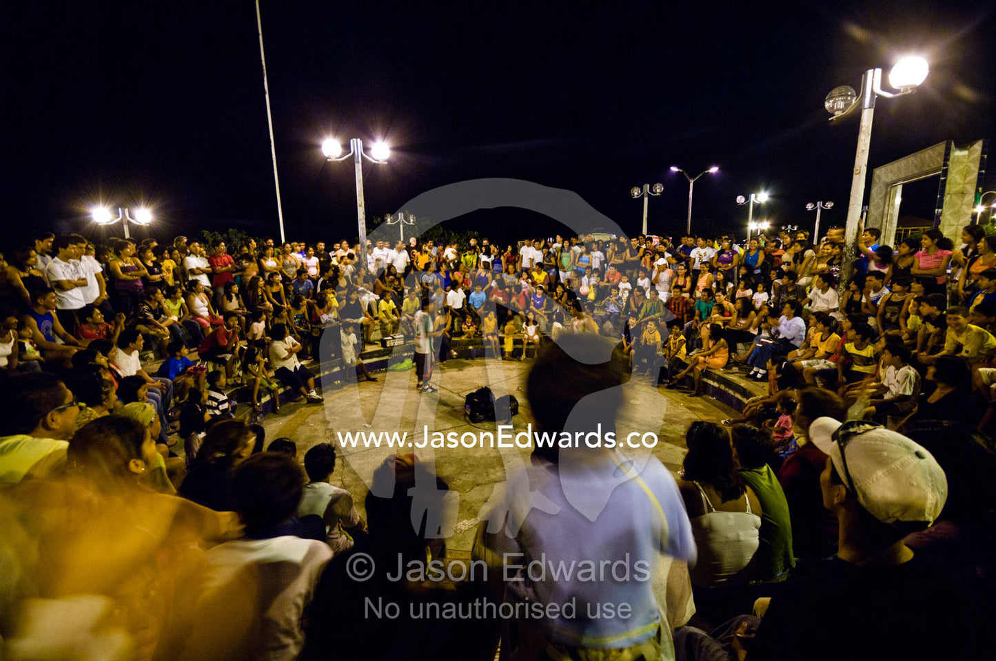 A crowd of onlookers is entertained by comedians at an open-air theatre in an Amazon river town. Iquitos, Amazon Basin, Loreto Region, Maynas Province, Peru.