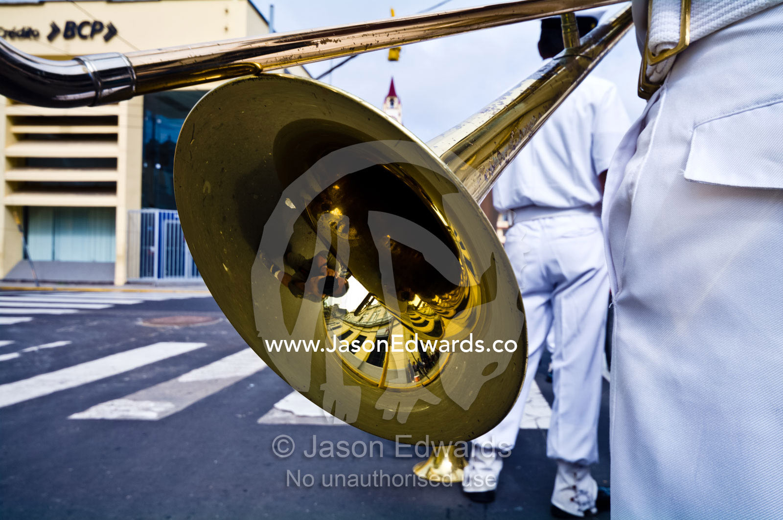 A navy band member with a brass trombone bell and slide at a military parade honoring fallen comrades. Plaza de Armas, Iquitos, Amazon Basin, Loreto Region, Maynas Province, Peru.