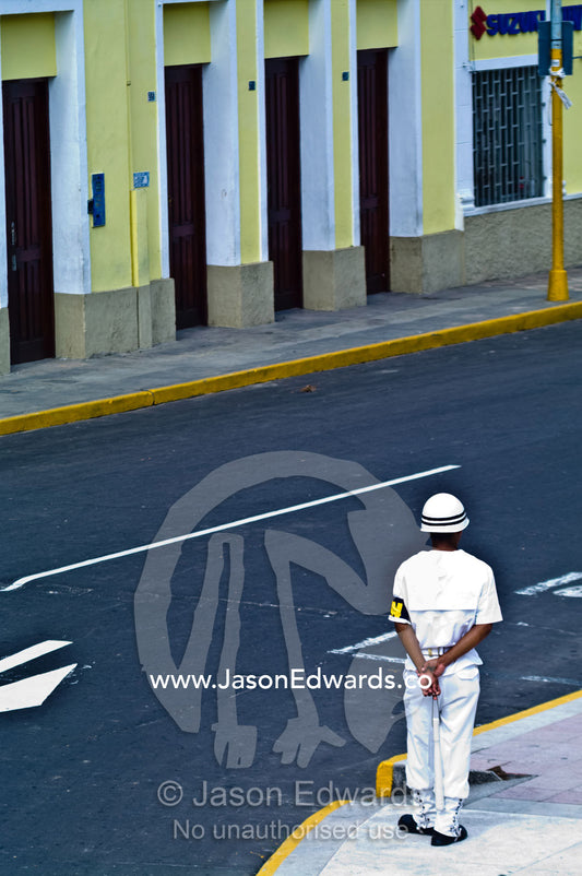 A military police officer patrols a street corner during a military parade honoring fallen comrades. Plaza de Armas, Iquitos, Amazon Basin, Loreto Region, Maynas Province, Peru.