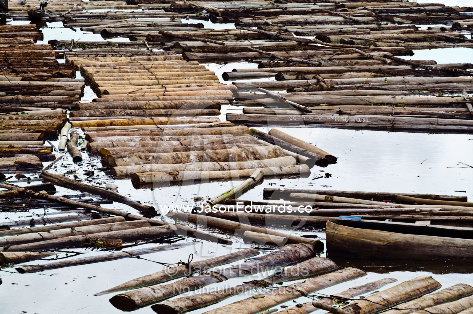 The Amazon River choked with logs from rainforest trees waiting to be processed in a logging mill. Puerto Masusa, Iquitos, Amazon River, Rio Amazonas, Amazon Basin, Loreto Region, Maynas Province, Peru.