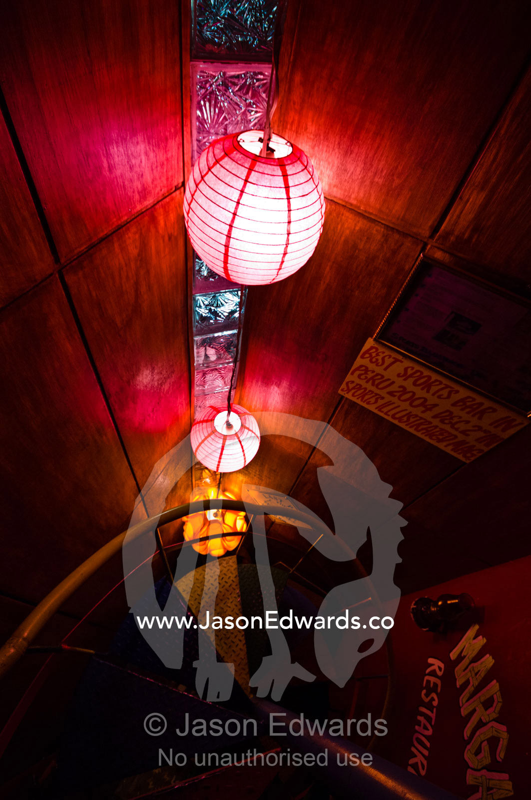 Pink paper lanterns illuminate a colourful stairwell in an Amazonian river town restaurant. Yellow Rose of Texas Restaurant, Iquitos, Amazon Basin, Loreto Region, Maynas Province, Peru.