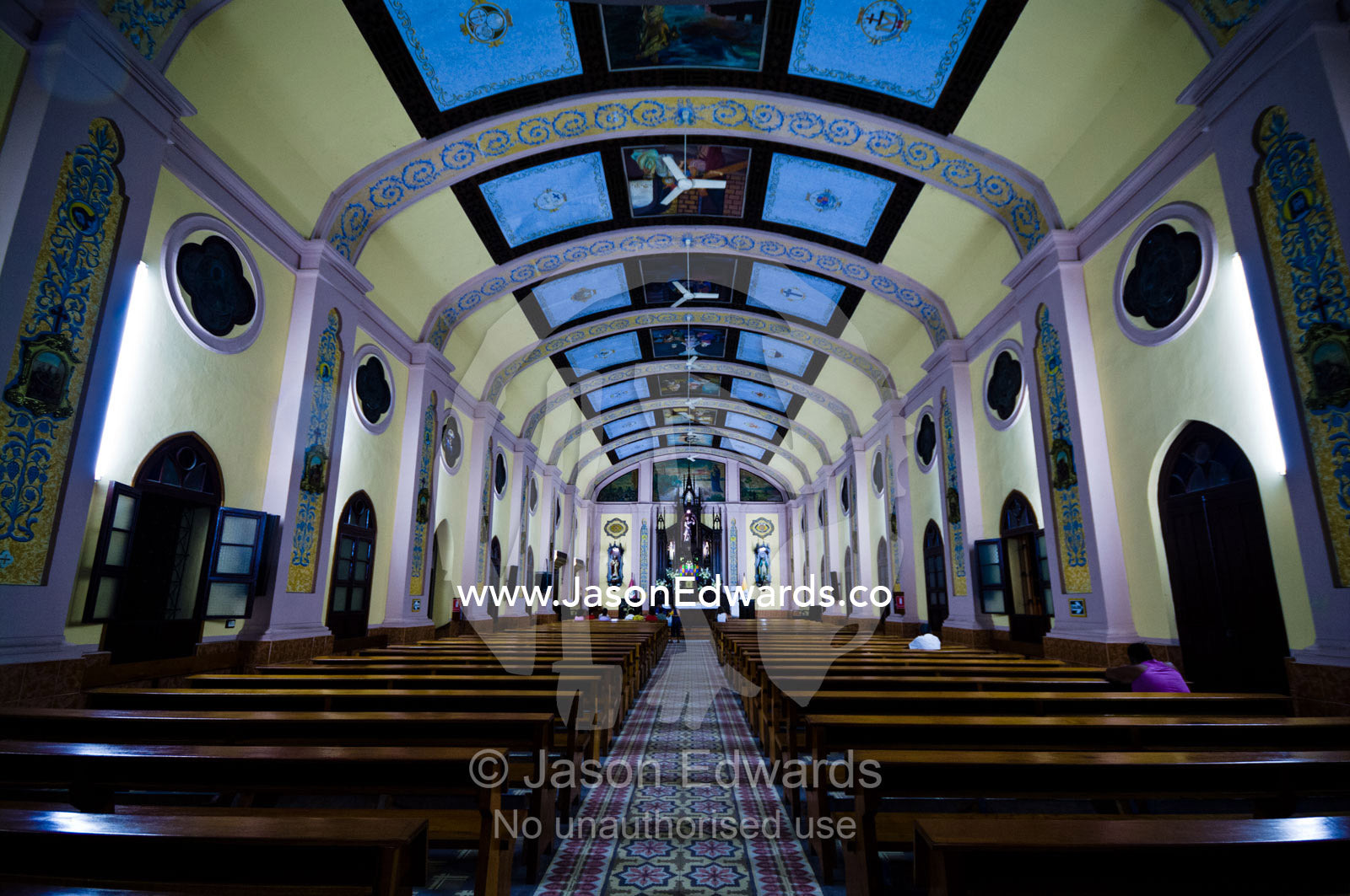 Parishioners pray in the pews of a Catholic church with a huge vaulted roof. San Juan Bautista Church, Iglesia Matriz, Cathedral of St John the Baptist, Iquitos, Amazon Basin, Loreto Region, Maynas Province, Peru.