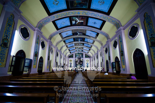 Parishioners pray in the pews of a Catholic church with a huge vaulted roof. San Juan Bautista Church, Iglesia Matriz, Cathedral of St John the Baptist, Iquitos, Amazon Basin, Loreto Region, Maynas Province, Peru.