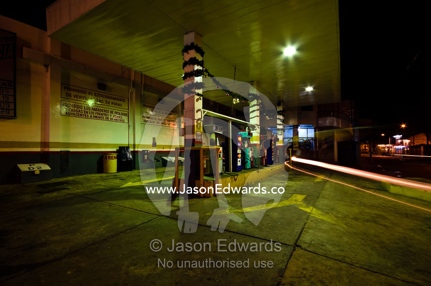 A motorbike auto rickshaw drives out of a petrol station after refuelling at night. Iquitos, Amazon Basin, Loreto Region, Maynas Province, Peru.