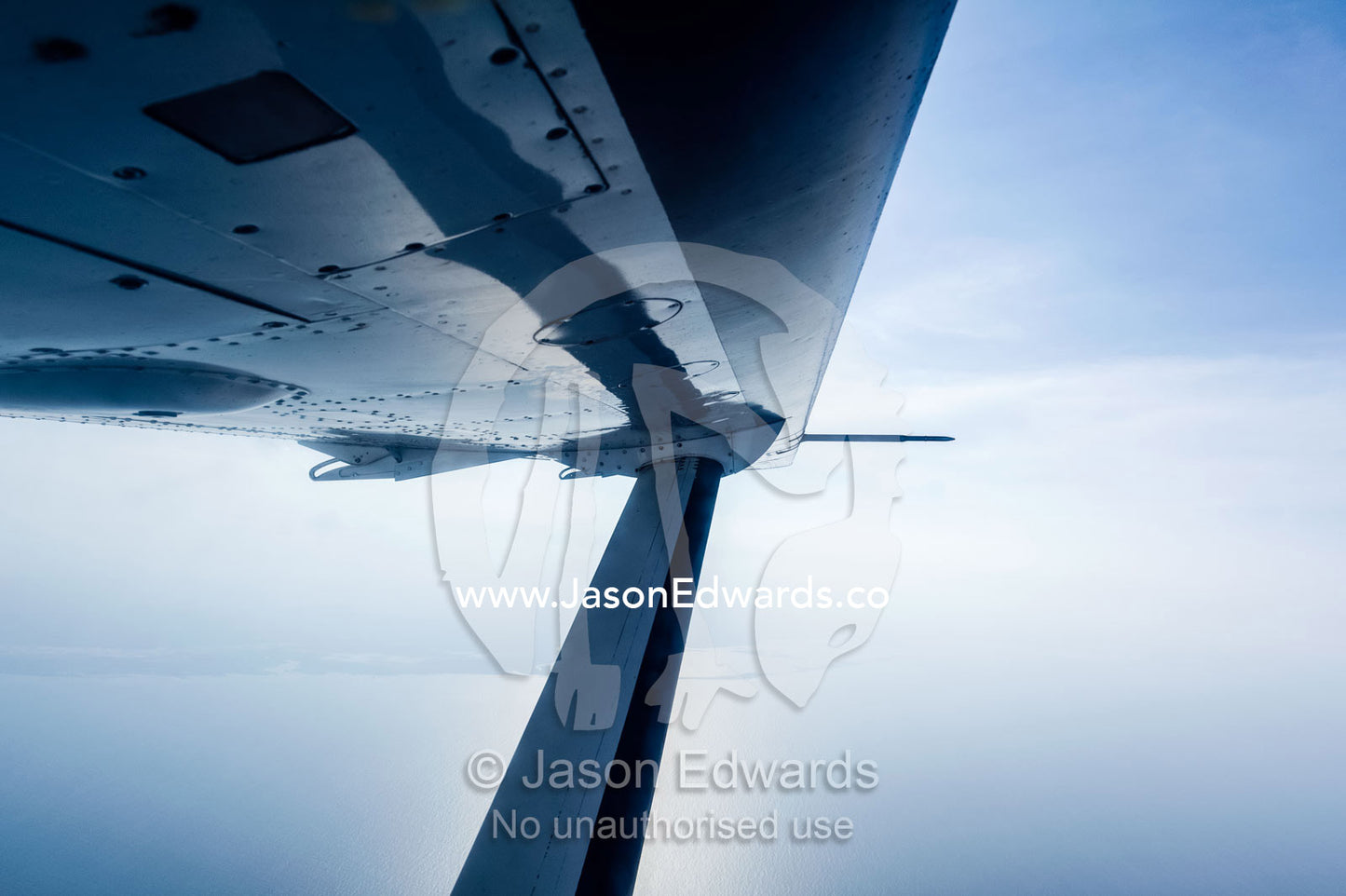 The leading edge and strut of a light plane wing in flight. Dar es Salaam, Dar es Salaam Bay, Tanzania.