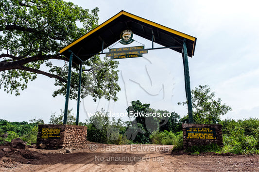 A dirt road passes through the entrance gate to Lake Manyara National Park. Karatu, Lake Manyara National Park, Arusha Region, Tanzania, Africa.