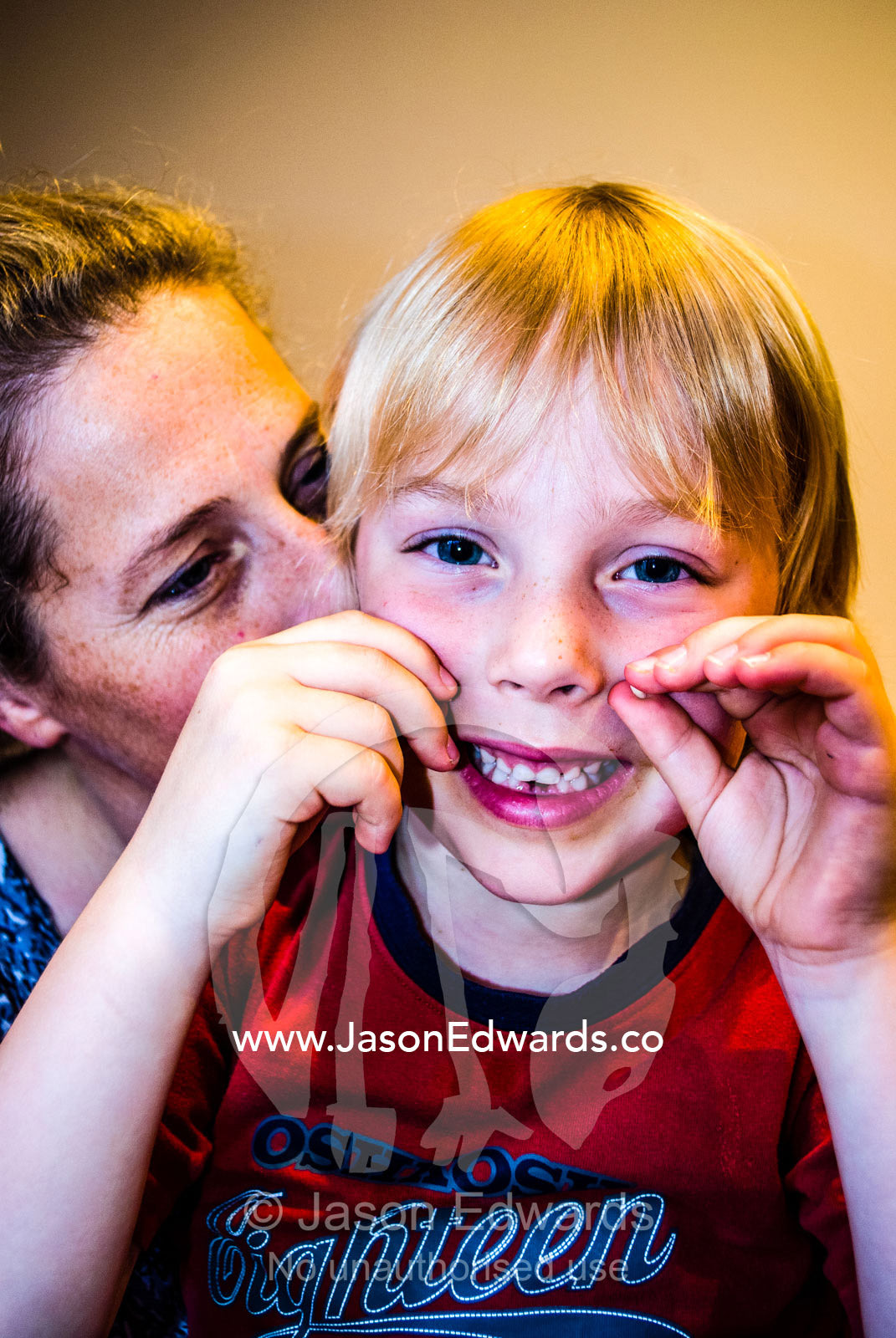 A boy and his mother proudly display his first teeth that fell out. Carlton North, Melbourne, Victoria, Australia.
