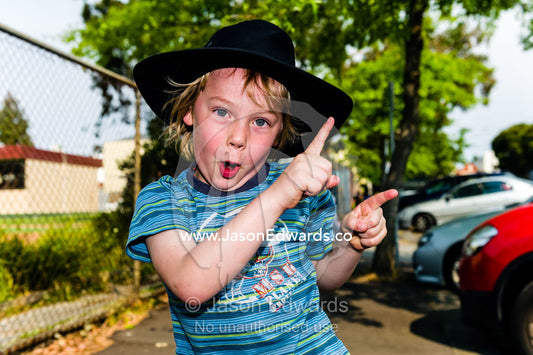 A boy dances for the camera during a school fundraising walkathon. Carlton North Primary School, Carlton North, Melbourne, Victoria, Australia.