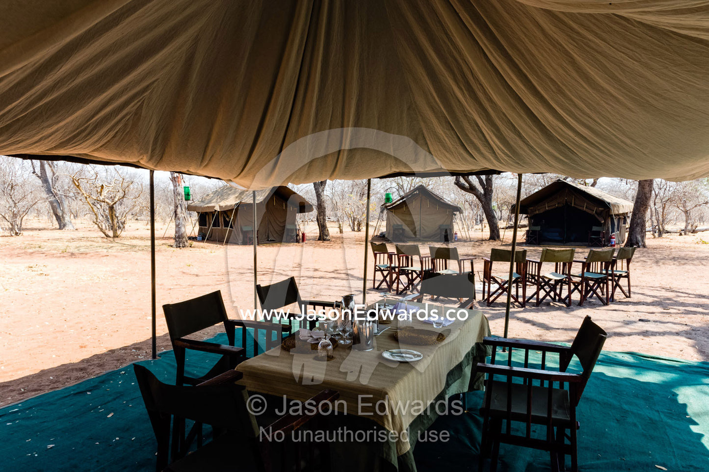 A tented safari camp dining room and canvas chairs in a national park. Chobe River, Chobe National Park, Botswana.