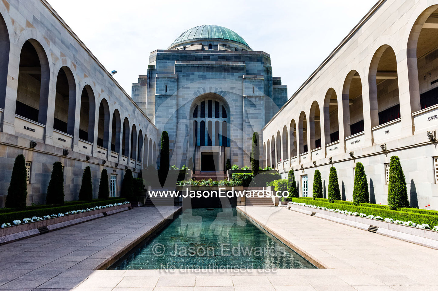 Cloisters containing the Roll of Honour overlook the Memorial Courtyard, Eternal Flame and Memorial Pool leading to the Hall of Memory. Australian War Memorial, Canberra, Australian Capital Territory, Australia.