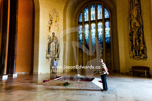 An elderly man pays his respects at the Tomb of the Unknown Soldier in the Hall of Memory. Australian War Memorial, Canberra, Australian Capital Territory, Australia.