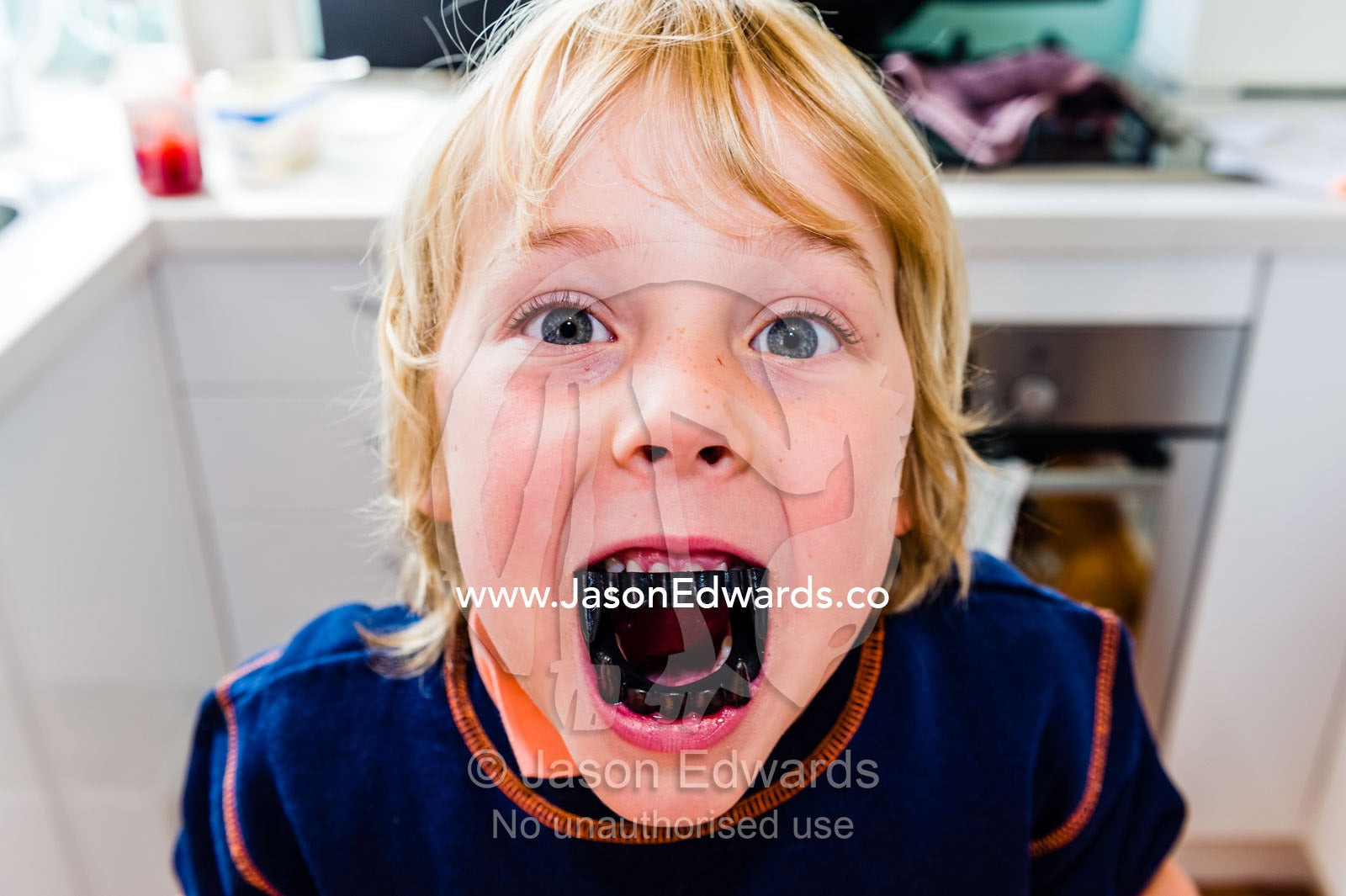 A boy shows his plastic vampire teeth to trick-or-treat at halloween. Carlton North, Melbourne, Victoria, Australia.