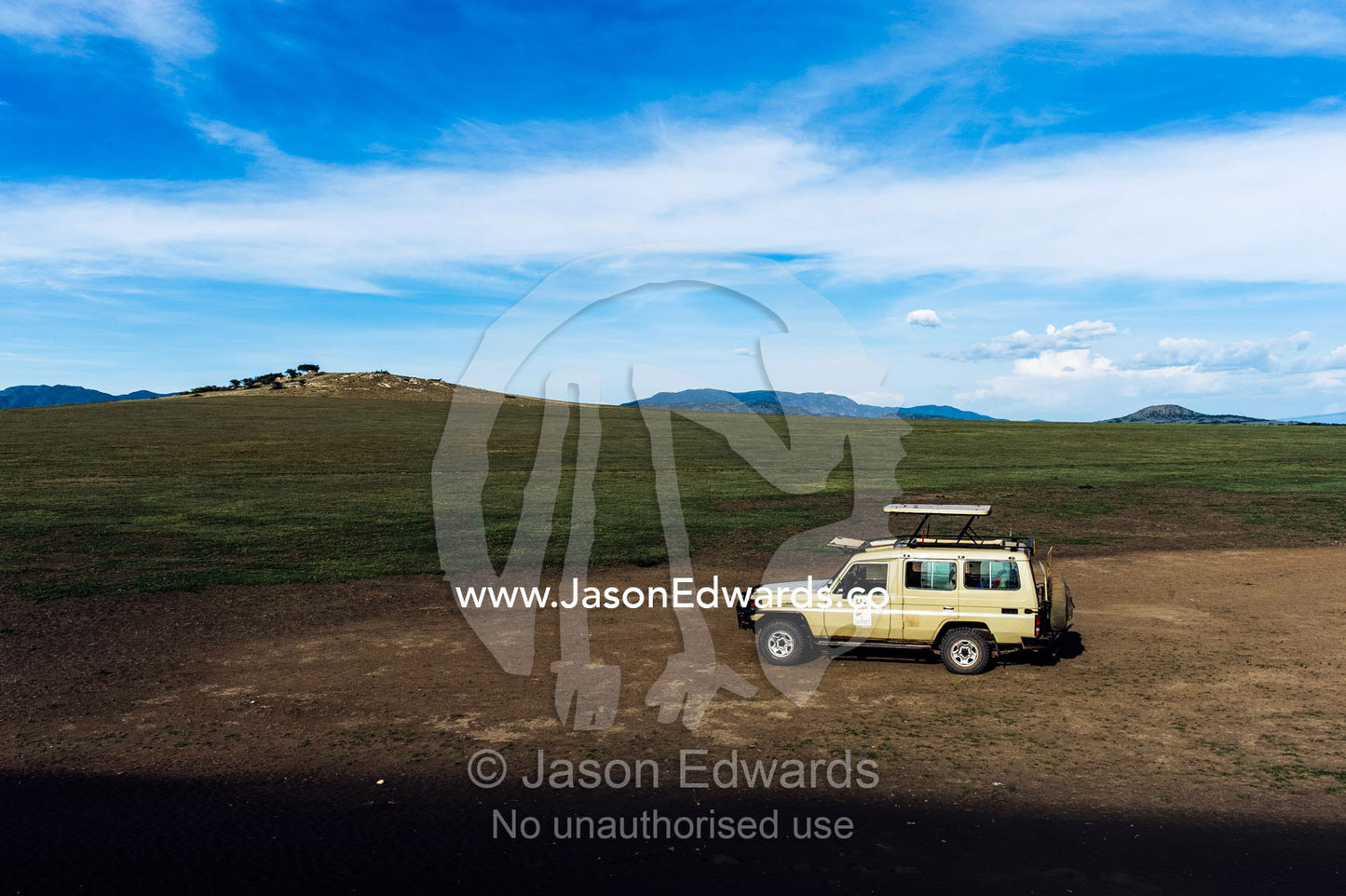 An African safari 4WD on a volcanic sand dune on the savannah plain. Shifting Sands, Ngorongoro Conservation Area, Ngorongoro District, Tanzania.