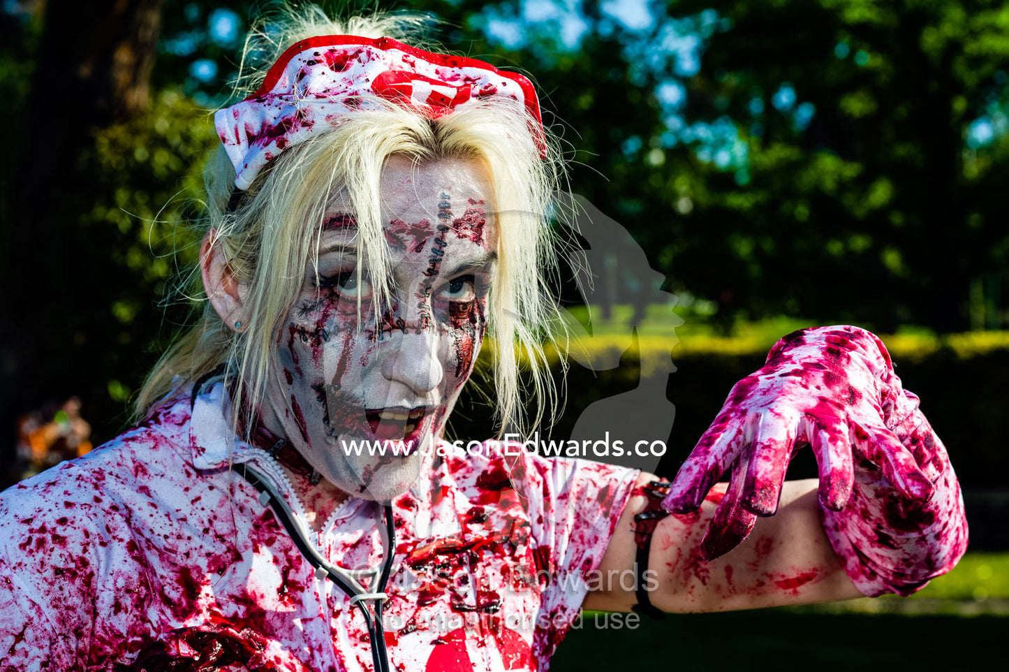 A blood-soaked snarling nurse dripping blood dressed as a zombie. Queen Victoria Gardens, Royal Botanic Gardens, South Yarra, Melbourne, Victoria, Australia.