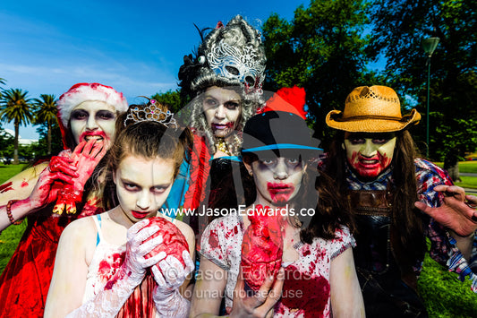 A family dresses as zombies eating fingers and hearts at a festival. Queen Victoria Gardens, Royal Botanic Gardens, South Yarra, Melbourne, Victoria, Australia.