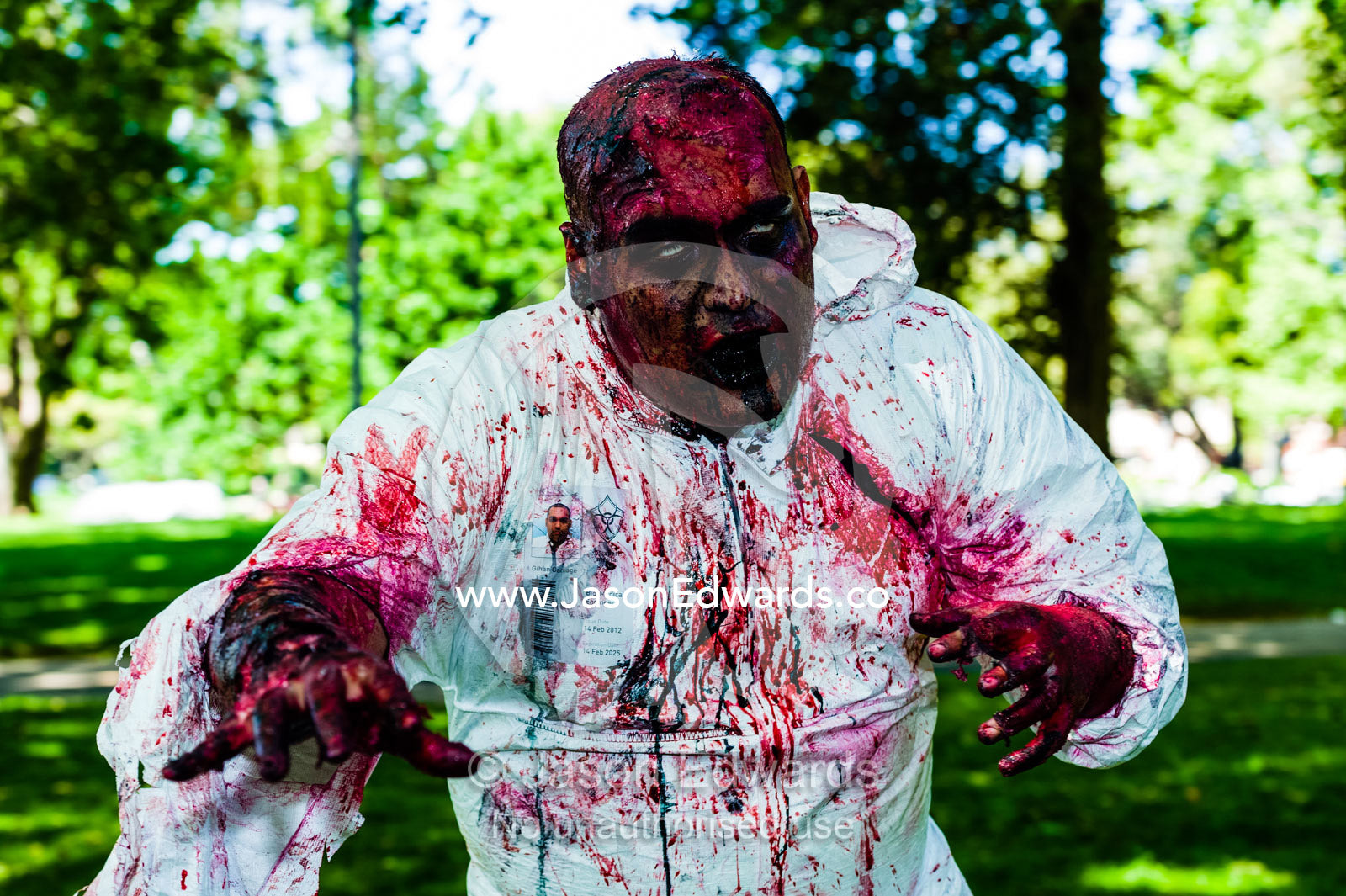 A hospital research technician zombie in a blood-soaked bio hazard suit. Carlton Gardens, World Heritage Site, Carlton, Melbourne, Victoria, Australia.