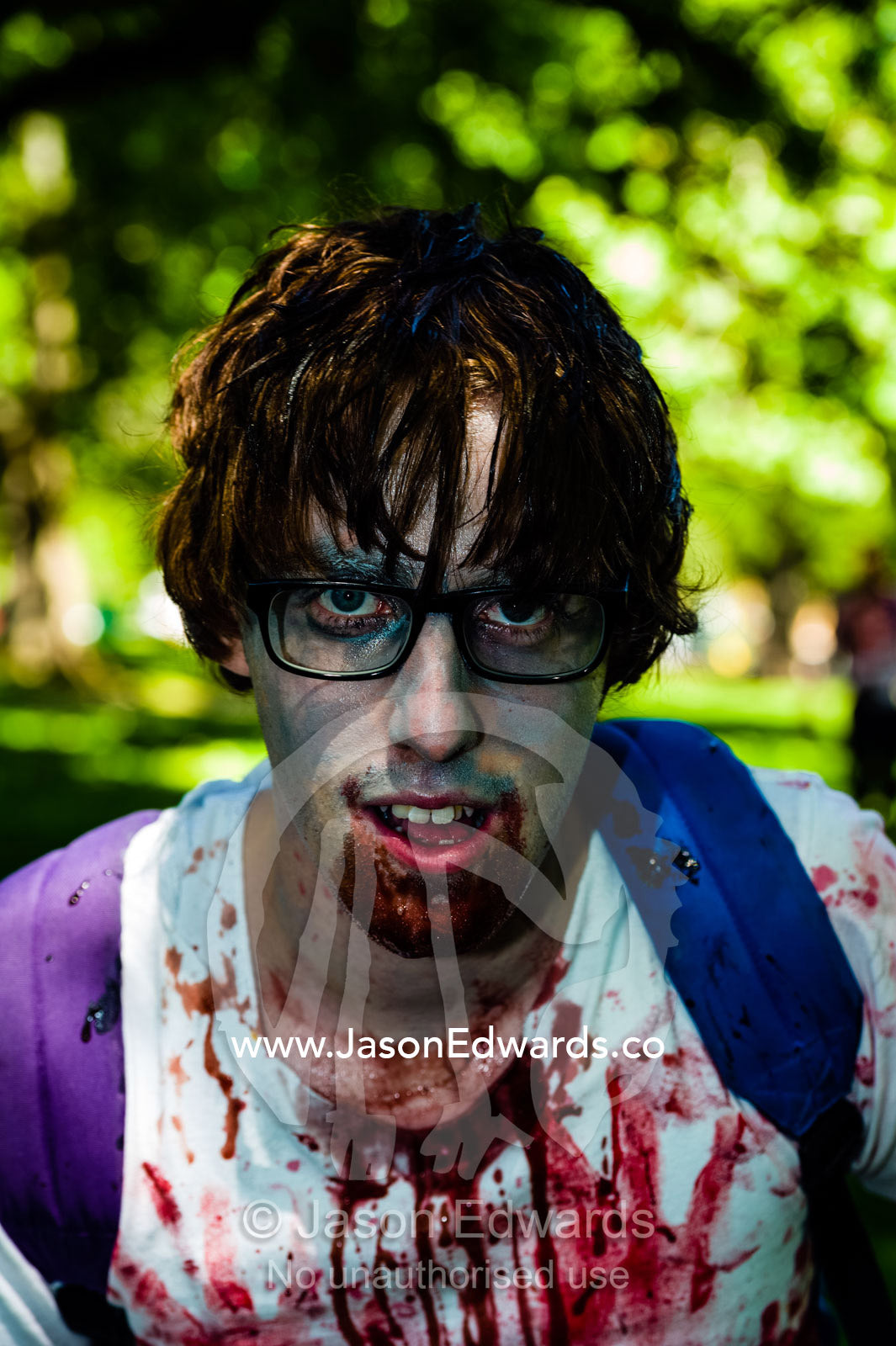 A student zombie wearing glasses drooling blood at a festival. Carlton Gardens, World Heritage Site, Carlton, Melbourne, Victoria, Australia.
