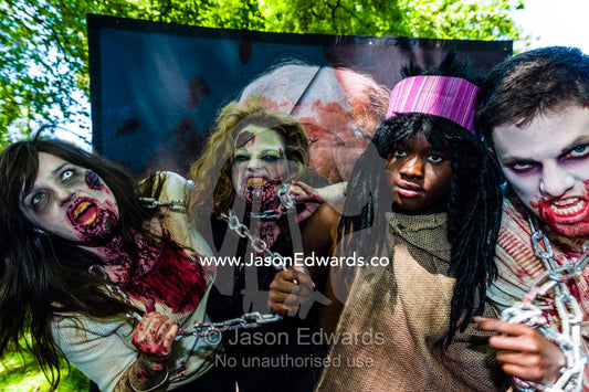 People dressed as zombies held by chains by a character from the Walking Dead. Carlton Gardens, World Heritage Site, Carlton, Melbourne, Victoria, Australia.