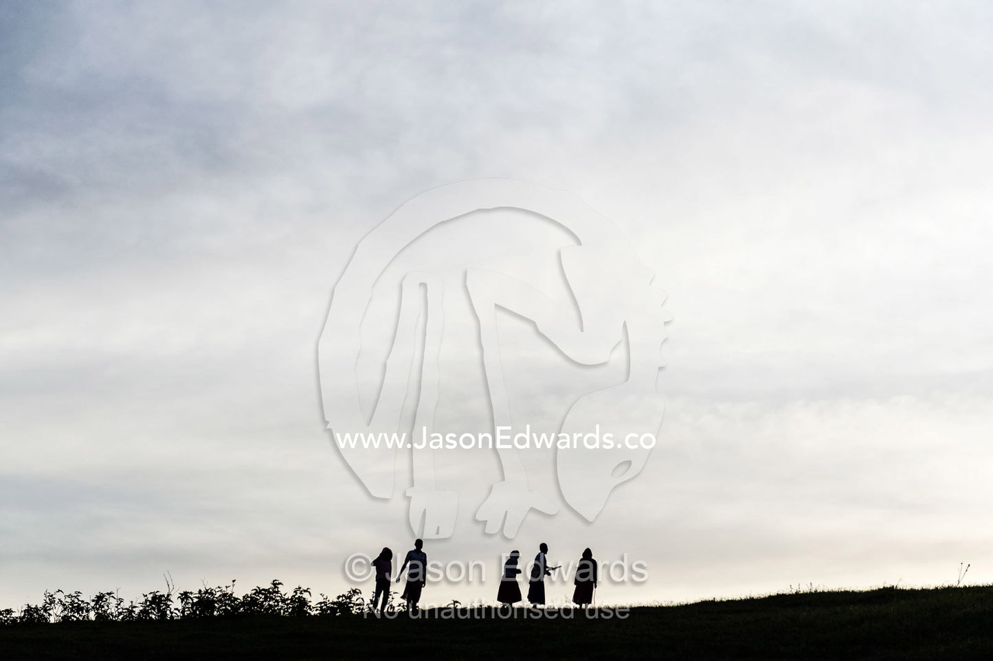 Teenage girls from an orphanage silhouette on the horizon of a farm at sunset. Karatu, Rhotia Valley Lodge, Rhotia Valley, Karatu District, Arusha Region, Tanzania, Africa.