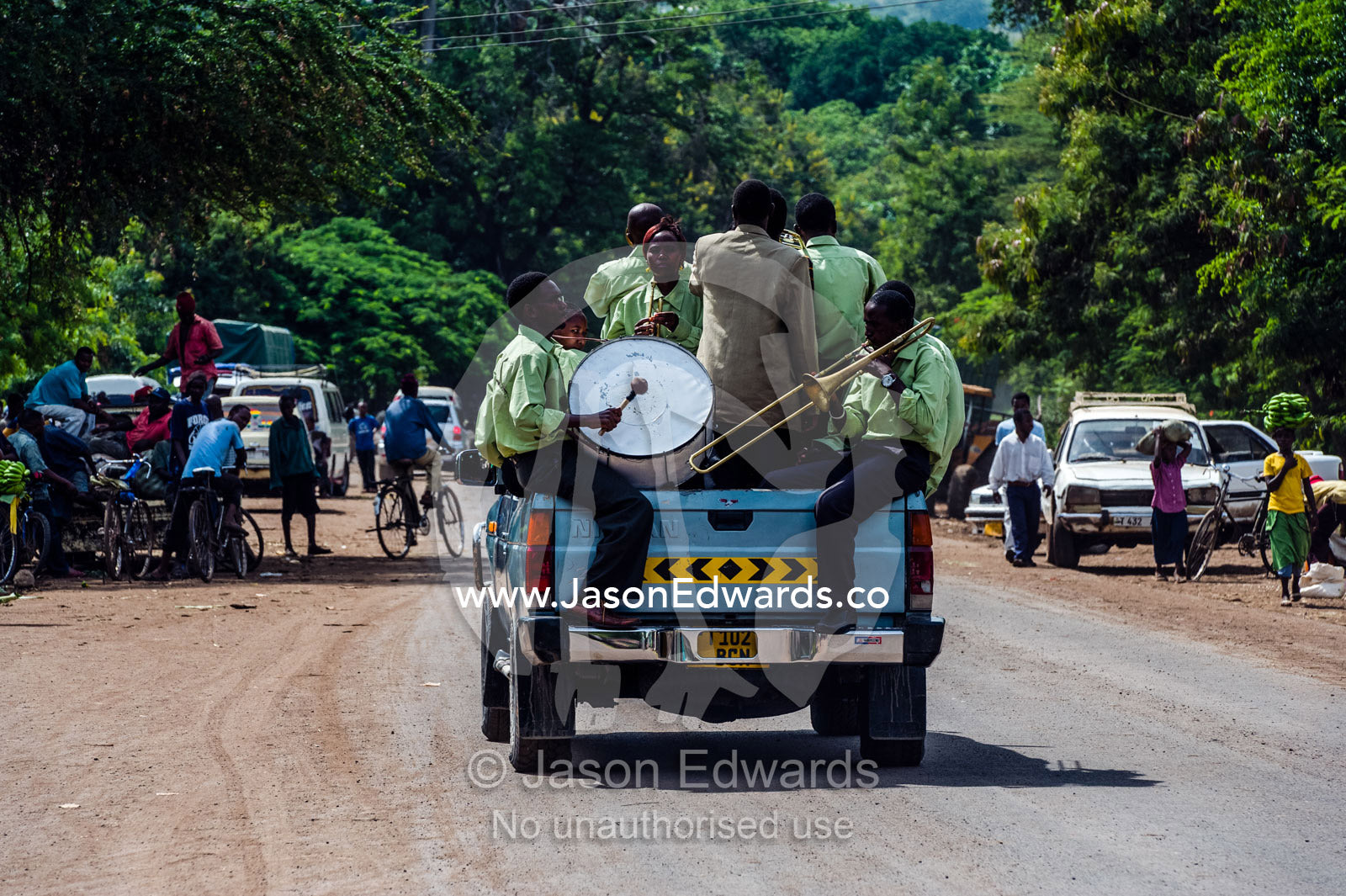 A band plays music for a wedding procession from a utility vehicle in the main street of a village. Mto Wa Mbu, Lake Manyara National Park, Monduli District, Arusha Region, Tanzania, Africa.