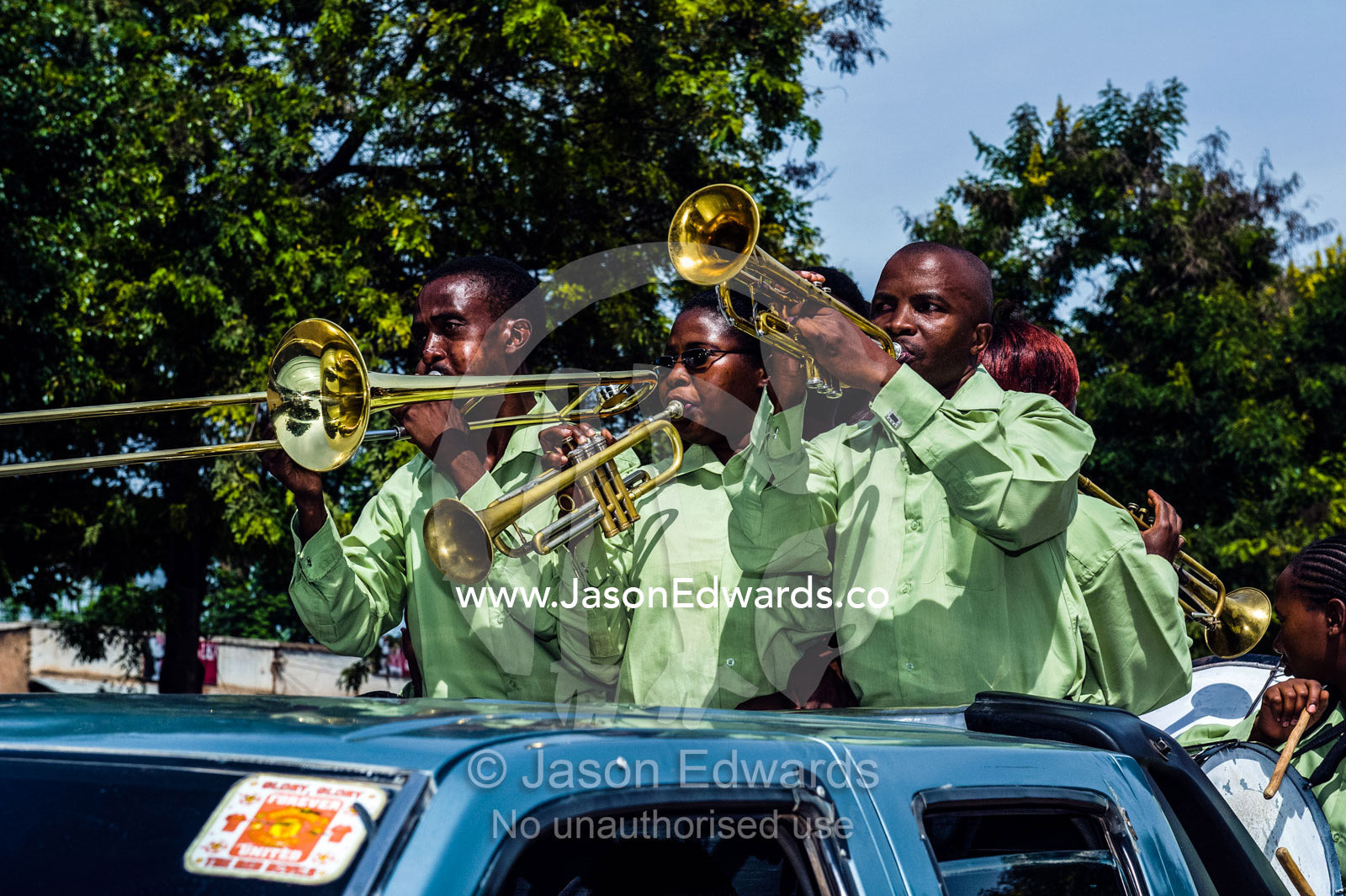 A band plays music for a wedding procession from a utility vehicle in the main street of a village. Mto Wa Mbu, Lake Manyara National Park, Monduli District, Arusha Region, Tanzania, Africa.
