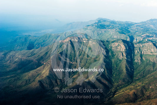 Folded, rugged mountain peaks and sheer cliffs rise from the Great Rift Valley in Africa. Crater Highlands, Arusha District, Tanzania.
