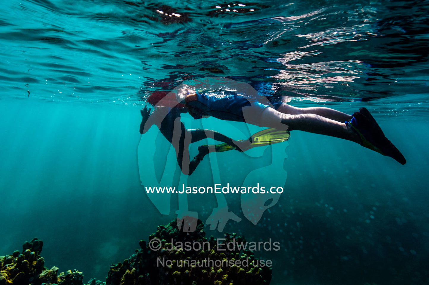 A scuba diving instructor assists a small boy to snorkel over a tropical coral reef using a floating rescue ring. Bwejuu, Blue Lagoon Reef, Unguja Island, Zanzibar, Tanzania.