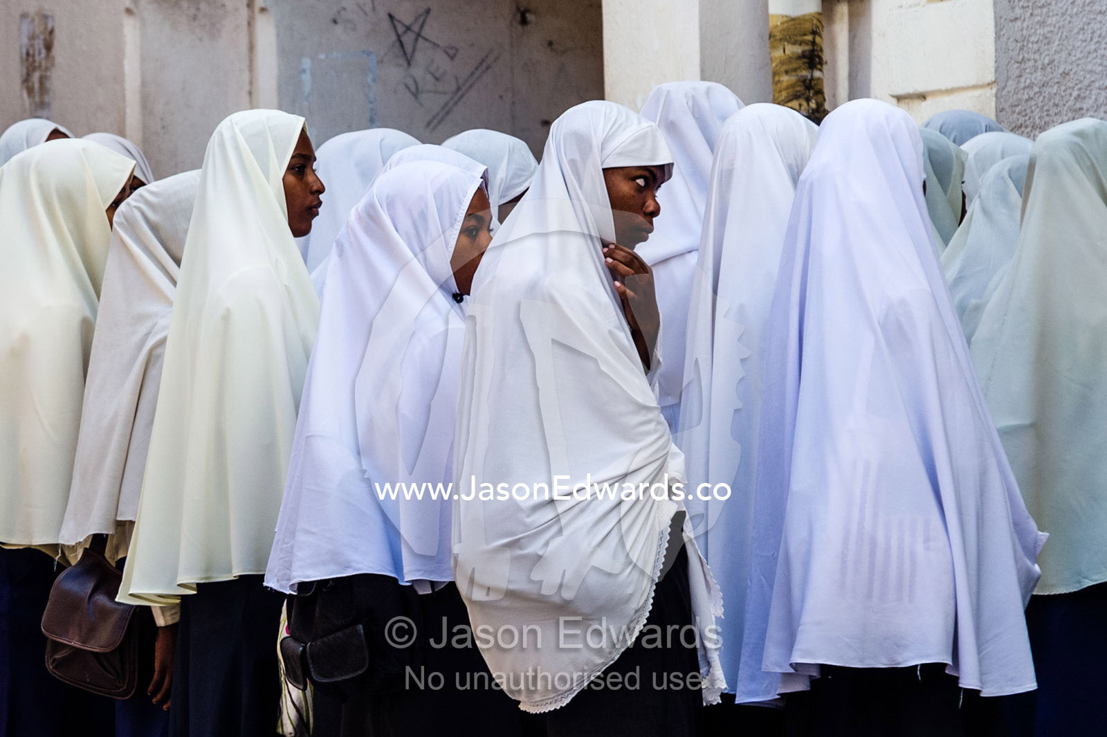 Muslim teenagers wait to enter class at the beginning of another school day. Stone Town, Mji Mkongwe, Zanzibar, Unguja Island, Zanzibar, Tanzania.