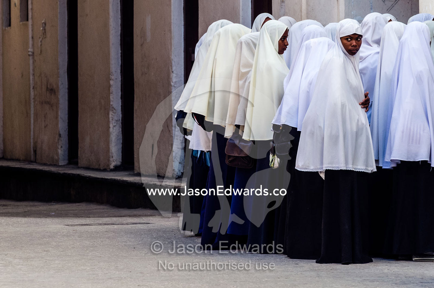 Muslim teenagers wait to enter class at the beginning of another school day. Stone Town, Mji Mkongwe, Zanzibar, Unguja Island, Zanzibar, Tanzania.