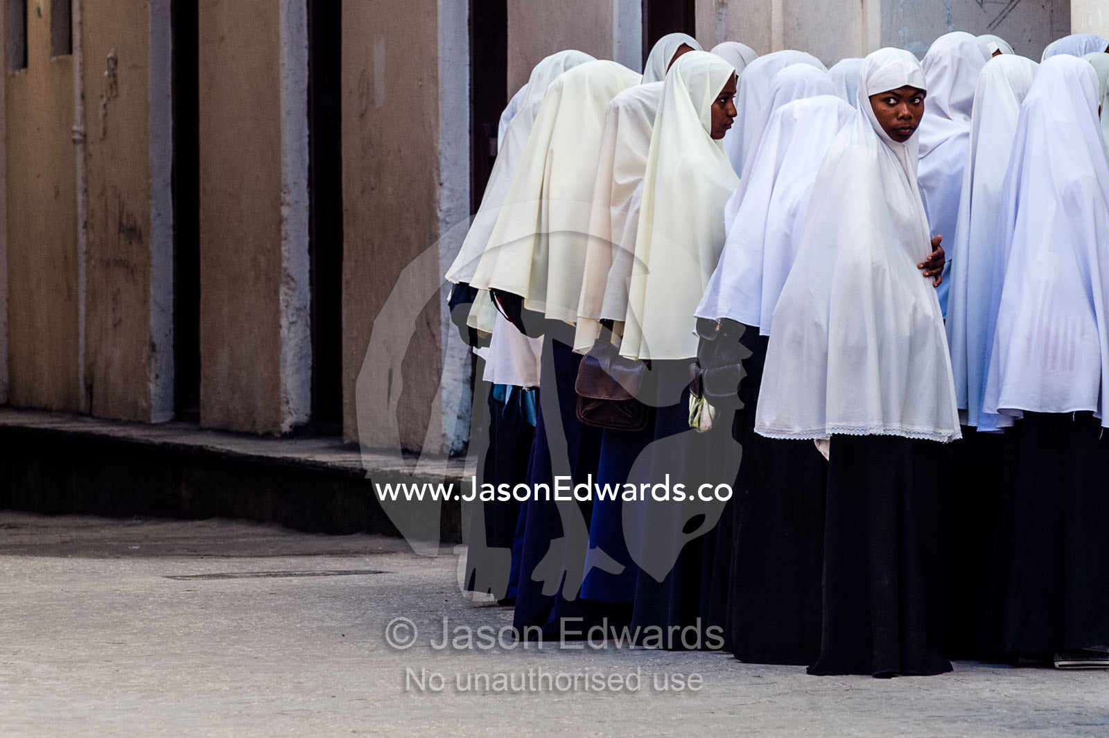 Muslim teenagers wait to enter class at the beginning of another school day. Stone Town, Mji Mkongwe, Zanzibar, Unguja Island, Zanzibar, Tanzania.