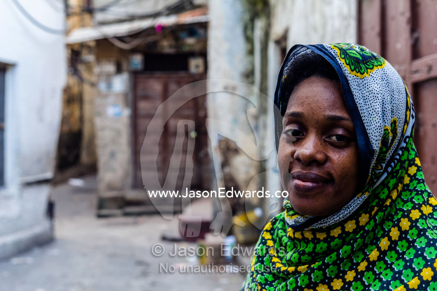 A Muslim woman makes her way through the quiet narrow alleys of Stone Town at dawn. Stone Town, Mji Mkongwe, Zanzibar, Unguja Island, Zanzibar, Tanzania.
