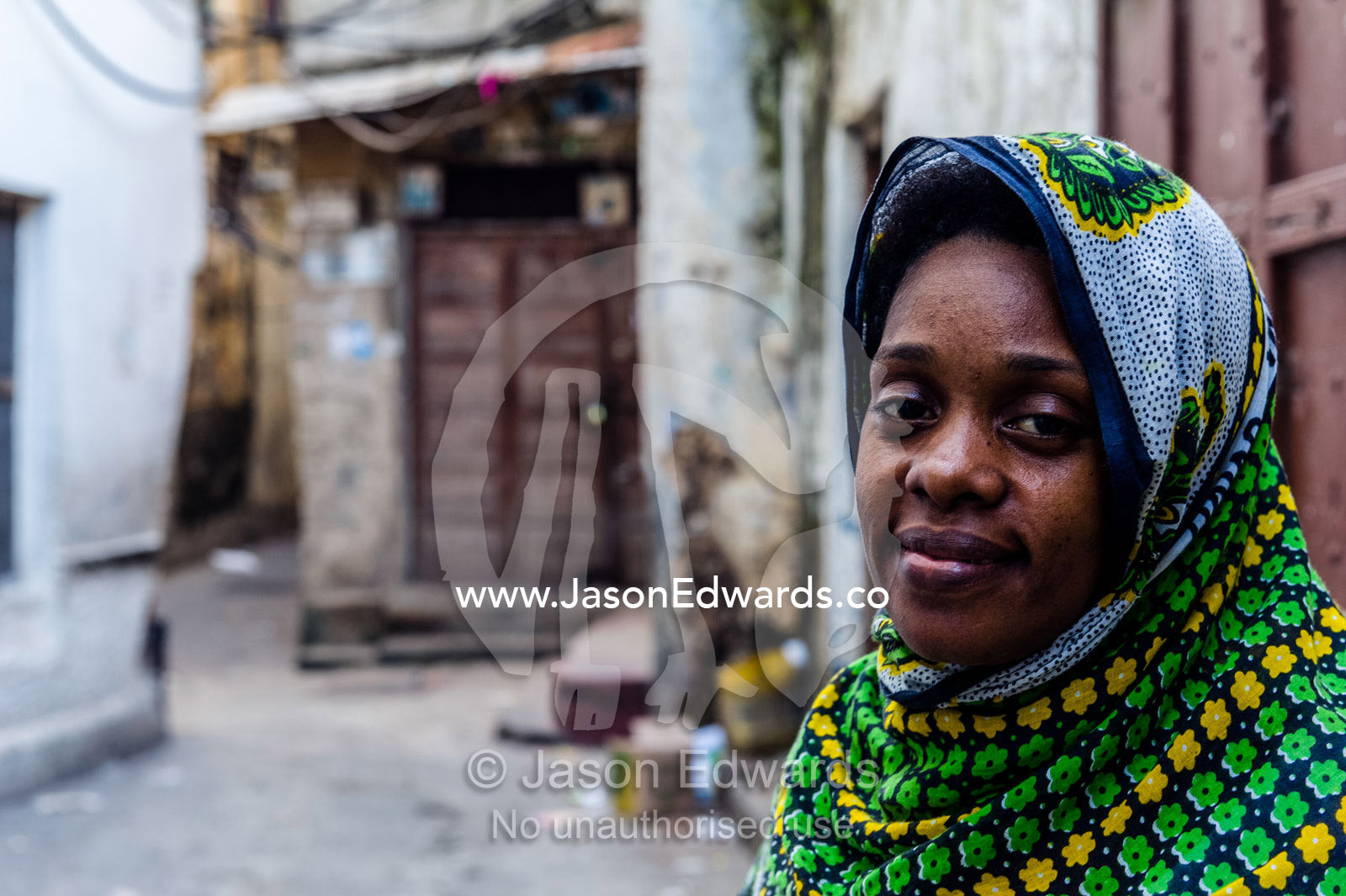 A Muslim woman makes her way through the quiet narrow alleys of Stone Town at dawn. Stone Town, Mji Mkongwe, Zanzibar, Unguja Island, Zanzibar, Tanzania.