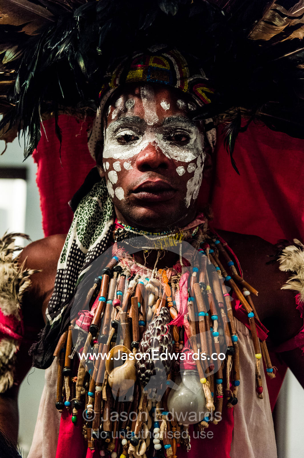 A Spirit dancer decorated in facial paint, shells, beads and a feathered headdress. Stone Town, Mji Mkongwe, Zanzibar, Unguja Island, Zanzibar, Tanzania.