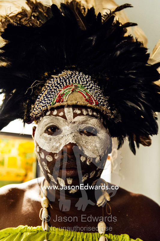 A Spirit dancer decorated in facial paint, shell necklace, beads and a feathered headdress. Stone Town, Mji Mkongwe, Zanzibar, Unguja Island, Zanzibar, Tanzania.
