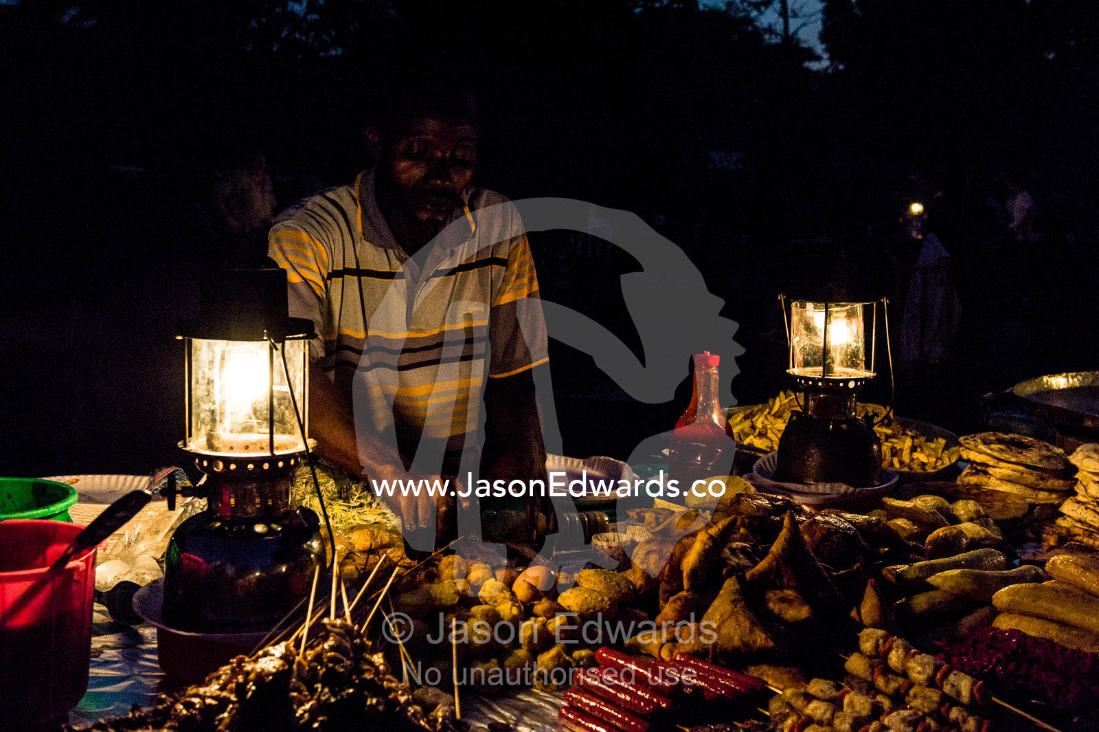 Food stall vendors prepare fresh food for shoppers at a night market by the Indian Ocean. Forodhani Gardens, Stone Town, Mji Mkongwe, Zanzibar, Unguja Island, Zanzibar, Tanzania.