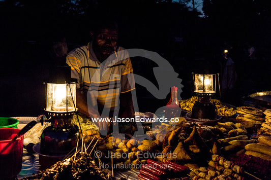 Food stall vendors prepare fresh food for shoppers at a night market by the Indian Ocean. Forodhani Gardens, Stone Town, Mji Mkongwe, Zanzibar, Unguja Island, Zanzibar, Tanzania.
