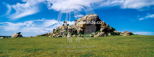 A rocky granite outcrop known as a kopje on a short grass savannah plain. Ngorongoro Conservation Area, Ngorongoro District, Tanzania.